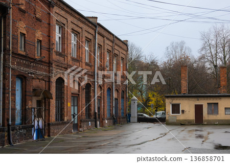 Old brick building and small structure in a quiet, wet courtyard during autumn Old brick building and small structure in a quiet, wet courtyard during autumn 136858701