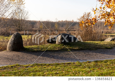 Large boulders sitting in a scenic park during autumn afternoon Large boulders sitting in a scenic park during autumn afternoon 136858821