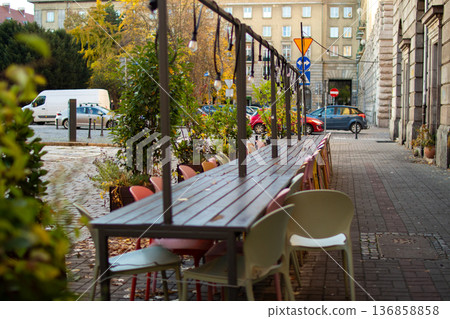 Outdoor dining area with colorful chairs on a quiet city street in autumn Outdoor dining area with colorful chairs on a quiet city street in autumn 136858858