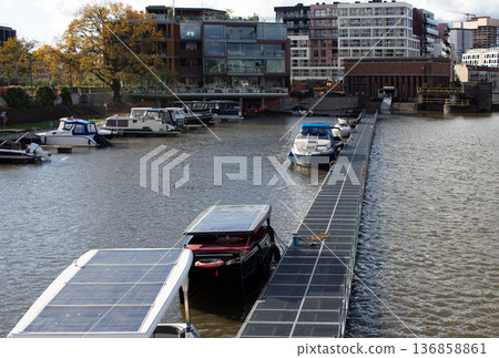 Boats docked along a modern marina in an urban waterfront setting 136858861