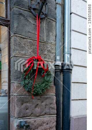 Wreath hanging on a stone wall near a cafe during the holiday season Wreath hanging on a stone wall near a cafe during the holiday season 136858868
