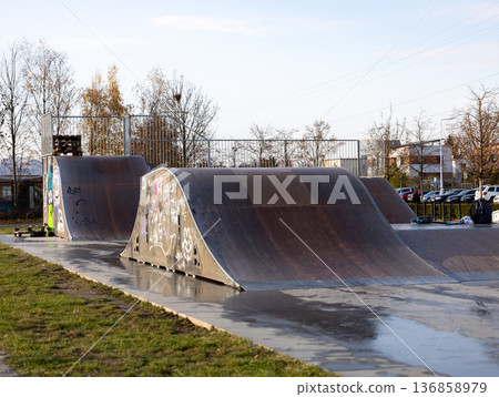 Skatepark ramps await riders on a sunny afternoon Skatepark ramps await riders on a sunny afternoon 136858979