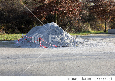 Construction site with gravel pile and safety barriers in a park setting Construction site with gravel pile and safety barriers in a park setting 136858981
