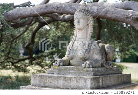 The stone sphinx, a mythical creature featuring a human head and a lion's body, is located in the gardens of Chiswick House in London. The stone sphinx, a mythical creature featuring a human head and a lion's body, is located in the gardens of Chiswick House in London. 136859271