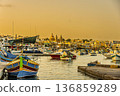 Pier and boats at sunset in the port of Marsaxlokk. Malta. 136859289
