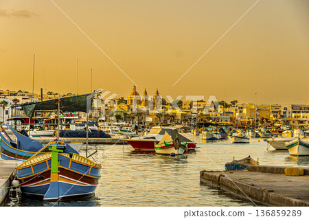 Pier and boats at sunset in the port of Marsaxlokk. Malta. Pier and boats at sunset in the port of Marsaxlokk. Malta. 136859289