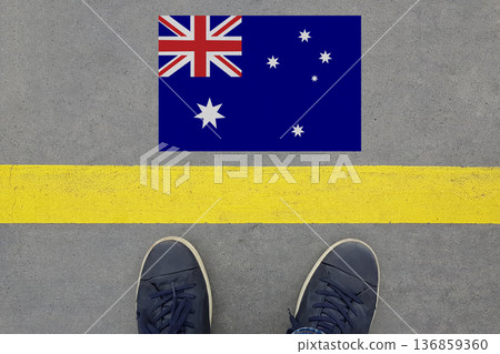 Start on an asphalt road with the Australian flag and legs in shoes. Business, Immigration Start on an asphalt road with the Australian flag and legs in shoes. Business, Immigration 136859360