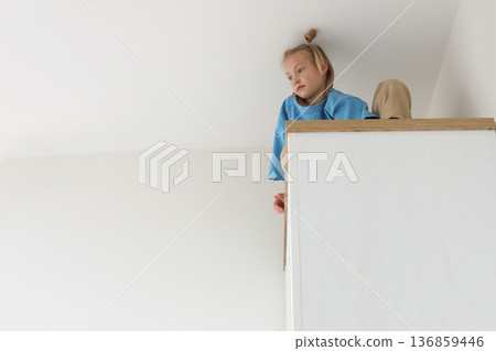 Healthy kid girl sitting on a high cabinet. Child 6 years old at Healthy kid girl sitting on a high cabinet. Child 6 years old at 136859446