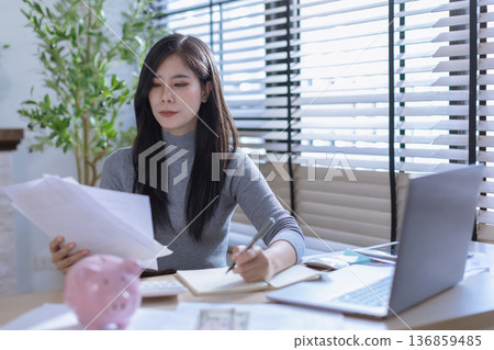 Business woman or accountant working on calculator to calculate business data in modern office. Business woman or accountant working on calculator to calculate business data in modern office. 136859485