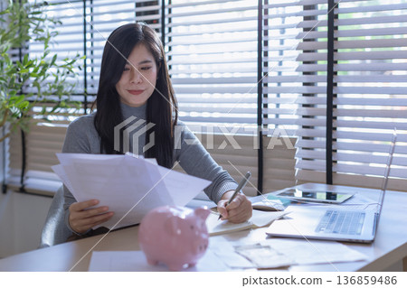 Business woman or accountant working on calculator to calculate business data in modern office. Business woman or accountant working on calculator to calculate business data in modern office. 136859486