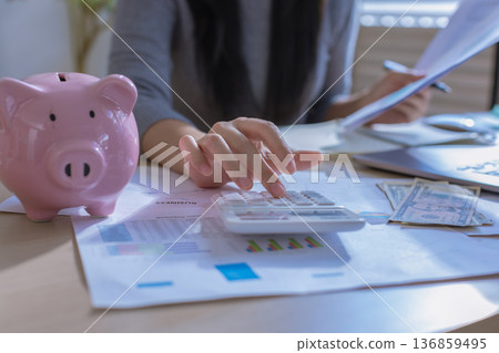 Business woman or accountant working on calculator to calculate business data in modern office. Business woman or accountant working on calculator to calculate business data in modern office. 136859495