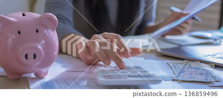 Business woman or accountant working on calculator to calculate business data in modern office. Business woman or accountant working on calculator to calculate business data in modern office. 136859496