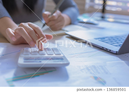Business woman or accountant working on calculator to calculate business data in modern office. Business woman or accountant working on calculator to calculate business data in modern office. 136859501