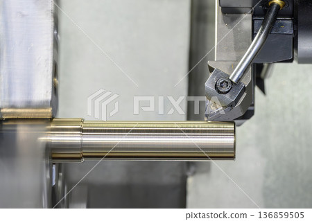 High-precision CNC lathe machine performing a final finishing cut on a cylindrical metal shaft with indexable carbide insert. High-precision CNC lathe machine performing a final finishing cut on a cylindrical metal shaft with indexable carbide insert. 136859505