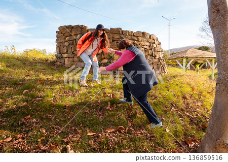 Elderly Caucasian grandmother spends a sunny afternoon with her granddaughter in a city park. Leisure, happiness, and family connection in retirement. Elderly Caucasian grandmother spends a sunny afternoon with her granddaughter in a city park. Leisure, happiness, and family connection in retirement. 136859516