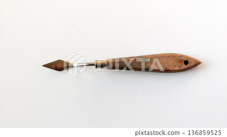 Palette knife with a wooden handle for cleaning paint from an artist's palette, top view. Art supplies for oil and acrylic painting Palette knife with a wooden handle for cleaning paint from an artist's palette, top view. Art supplies for oil and acrylic painting 136859525