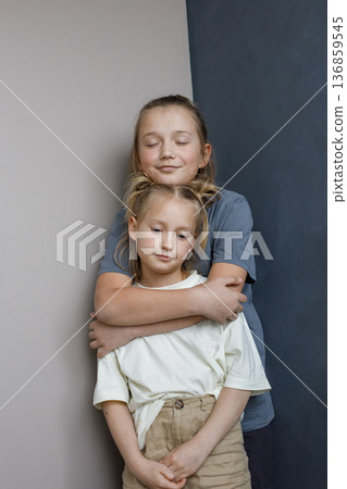 Adorable young sister and brother hugging indoor. Sibling children together portrait Adorable young sister and brother hugging indoor. Sibling children together portrait 136859545