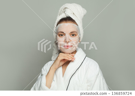 Portrait of young woman with moisturizing, rejuvenating white fabric sheet mask from her face  136859724