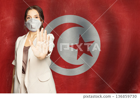 Confident woman in medical mask showing stop gesture open palm hand Tunisia background 136859730