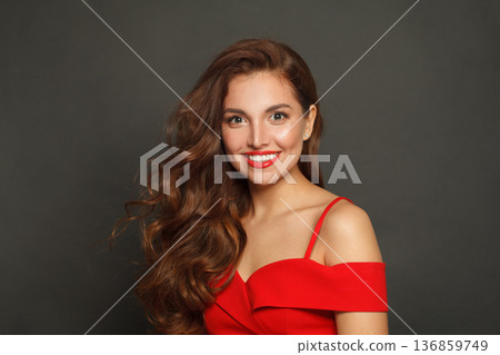 Pretty brunette woman with trendy make-up and brown curly hair wavy hairstyle and red lips makeup 136859749