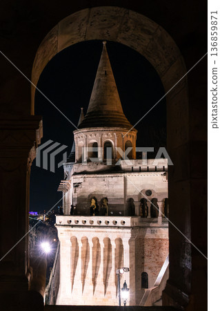 Fisherman's Bastion in Budapest illuminated at night. The historic structure features turrets and arches, surrounded by a quiet plaza. 136859871