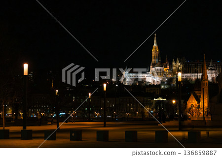 Fisherman's Bastion in Budapest illuminated at night. The historic structure features turrets and arches, surrounded by a quiet plaza. Fisherman's Bastion in Budapest illuminated at night. The historic structure features turrets and arches, surrounded by a quiet plaza. 136859887