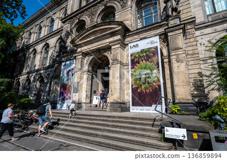 Berlin, germany, august 15, 2023. Visitors ascending steps into berlin's historic natural history museum, ornate stone facade under a sunny blue sky in summer 136859894