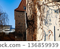 Building with vines near old stone wall under blue sky 136859939