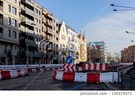 Road construction work in urban area with nearby buildings and signs Road construction work in urban area with nearby buildings and signs 136859973