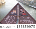 Stickers on bridge overlooking river in urban setting during early morning 136859975