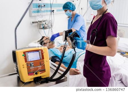 Doctors give resuscitation to a male patient in the emergency room. 136860747