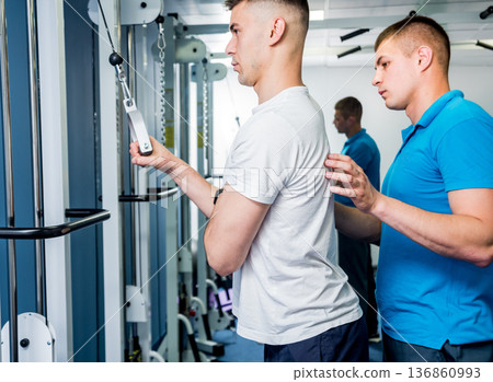Rehabilitation therapy. Young man doing exercises on mat Rehabilitation therapy. Young man doing exercises on mat 136860993