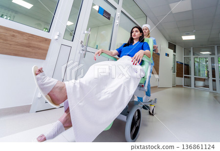 Nurse moves mobile medical chair with patient at hospital. Medical equipment. Nurse moves mobile medical chair with patient at hospital. Medical equipment. 136861124