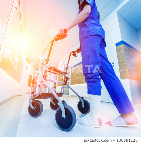 Patient on rollator with hand brakes moving in hospital 136861126