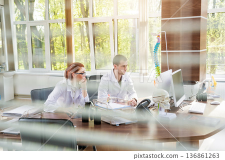 Two doctors having medical council in hospital. Discussing medical issues. Two doctors having medical council in hospital. Discussing medical issues. 136861263