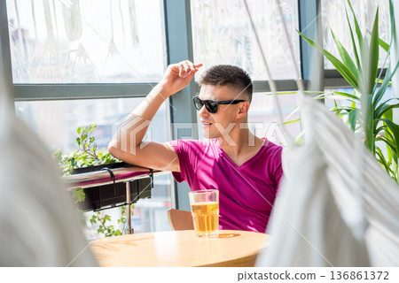 Young man in the pub. Drinking beer, eating pizza. Young man in the pub. Drinking beer, eating pizza. 136861372