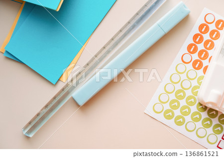 Paper trimmer with blue cardstock and sticker sheet on pastel background, minimal paper craft concept Paper trimmer with blue cardstock and sticker sheet on pastel background, minimal paper craft concept 136861521