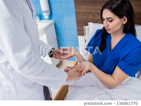 Traumatologist examining patient hands in modern hospital Traumatologist examining patient hands in modern hospital 136861770