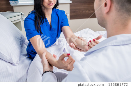 Traumatologist examining patient hands in modern hospital Traumatologist examining patient hands in modern hospital 136861772