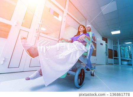 Nurse moves mobile medical chair with patient at hospital. Medical equipment. 136861778