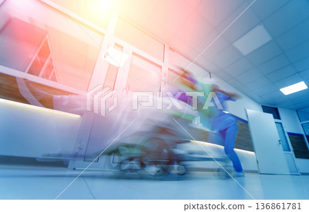 Nurse moves mobile medical chair with patient at hospital. Medical equipment. Blurred abstract background 136861781