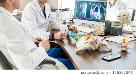 Doctor show polyaxial screw on the spine model. Spine fixation systems Doctor show polyaxial screw on the spine model. Spine fixation systems 136861848