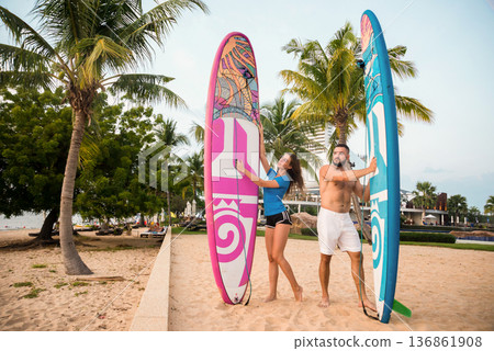 Two young surfers with boards on the beach Two young surfers with boards on the beach 136861908
