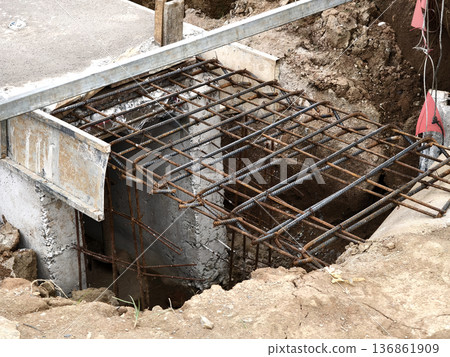 Narrow ditch with reinforcement, waterproof concrete trench bounded by soil and support stakes Narrow ditch with reinforcement, waterproof concrete trench bounded by soil and support stakes 136861909