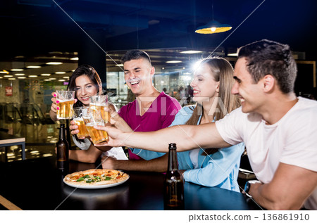 Cheerful friends in the pub. Drinking beer, wine and whisky 136861910