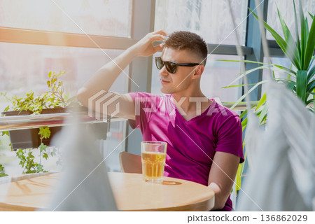 Young man in the pub. Drinking beer, eating pizza. Young man in the pub. Drinking beer, eating pizza. 136862029