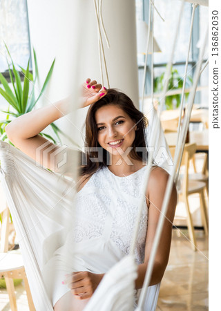 Portait of smiling young woman posing in the hammock Portait of smiling young woman posing in the hammock 136862030