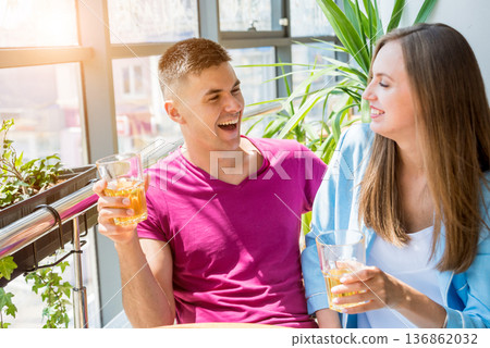 Cheerful couple in the pub. Drinking beer, talking, having fun. 136862032