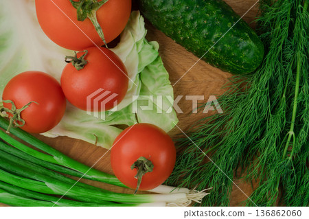 Fresh vegetables on a chopping wooden board, about to turn into a salad. Fresh vegetables on a chopping wooden board, about to turn into a salad. 136862060
