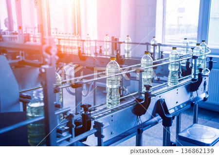 Bottling line of sunflower oil in bottles. Vegetable oil production plant. Bottling line of sunflower oil in bottles. Vegetable oil production plant. 136862139